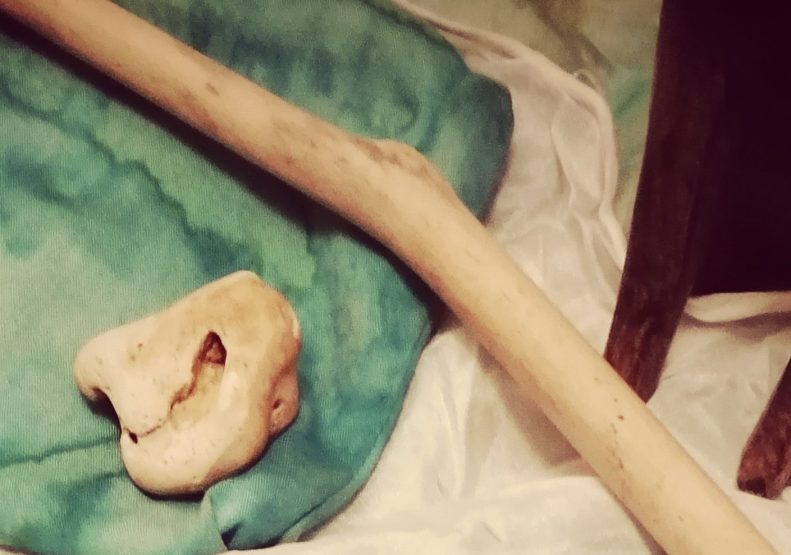 close up on wand and hagstone on green cloth